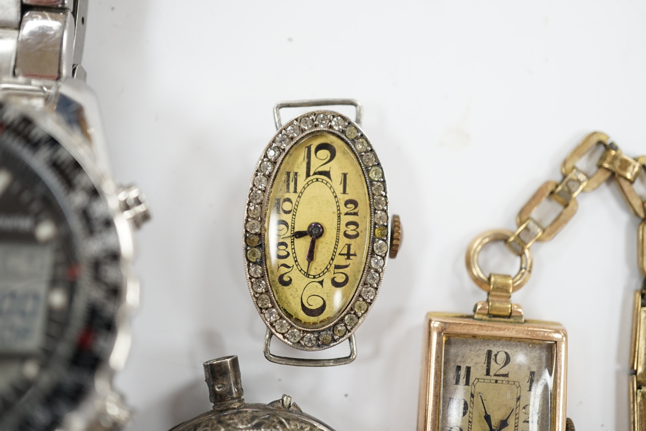 A lady's 1920's 9ct gold rectangular dial manual wind wrist watch, on a rolled gold bracelet, a similar silver and paste set wrist watch (no strap), an 800 standard white metal fob watch, a strap and a later Accurist ana